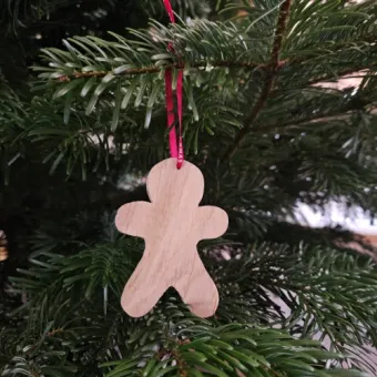 Sfeerfoto van eiken houten kersthanger in de vorm van een peperkoekmannetje