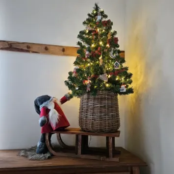 sfeerfoto kleine houten slee met kerstboom erop en een gnoom erbij