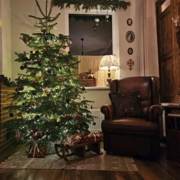 sfeerfoto van kleine houten slee onder de kerstboom